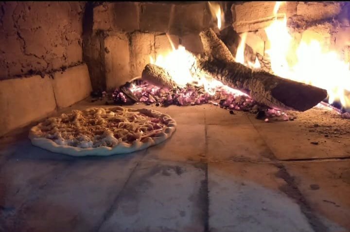 Pizza assando no forno a lenha da Pizzaria Sampa